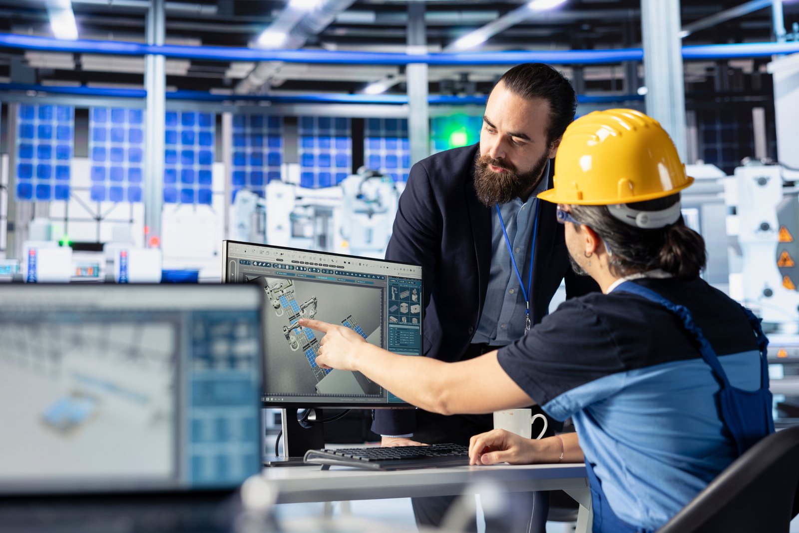 Dois homens em ambiente industrial com computador