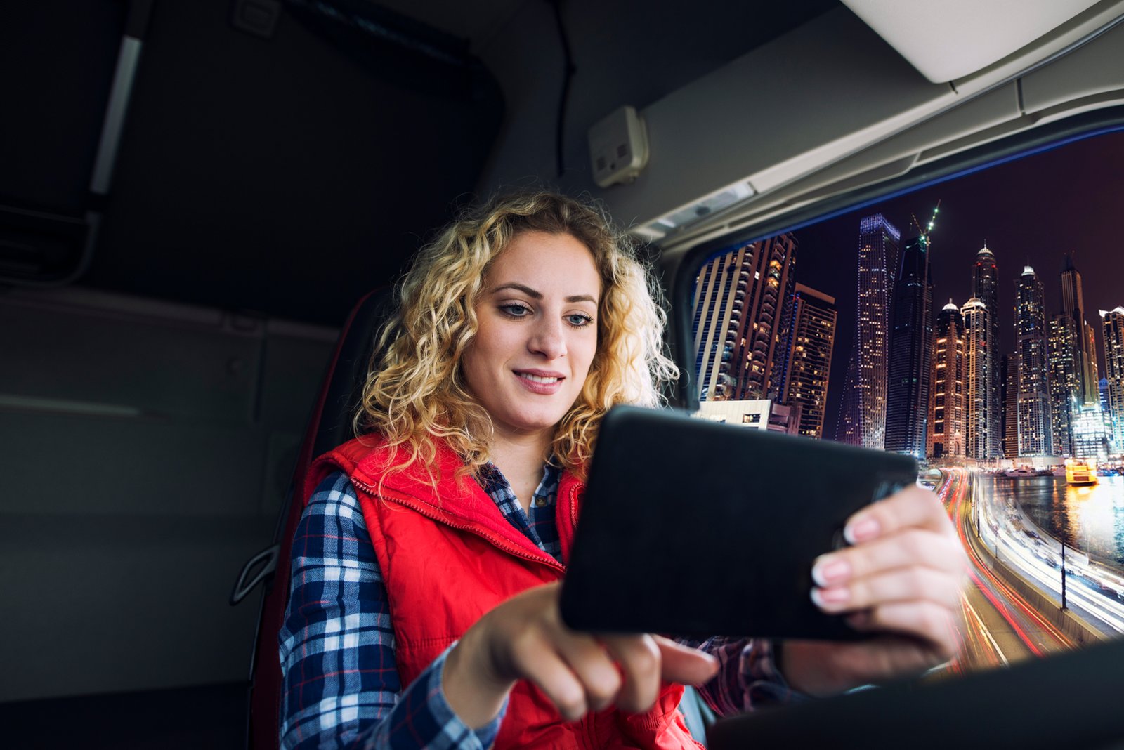 Mulher com tablet dentro de caminhão